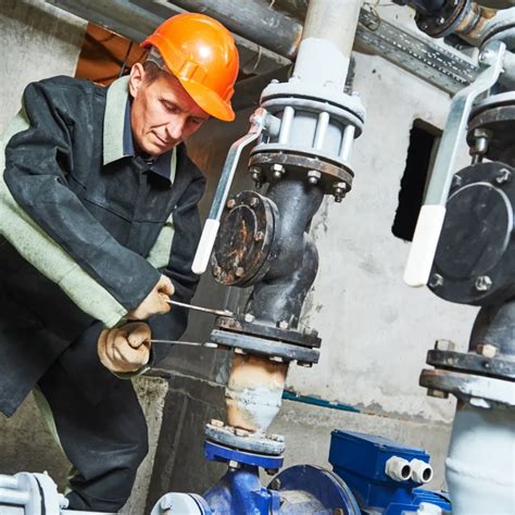 Technician working on pipe fittings in a fire pump room